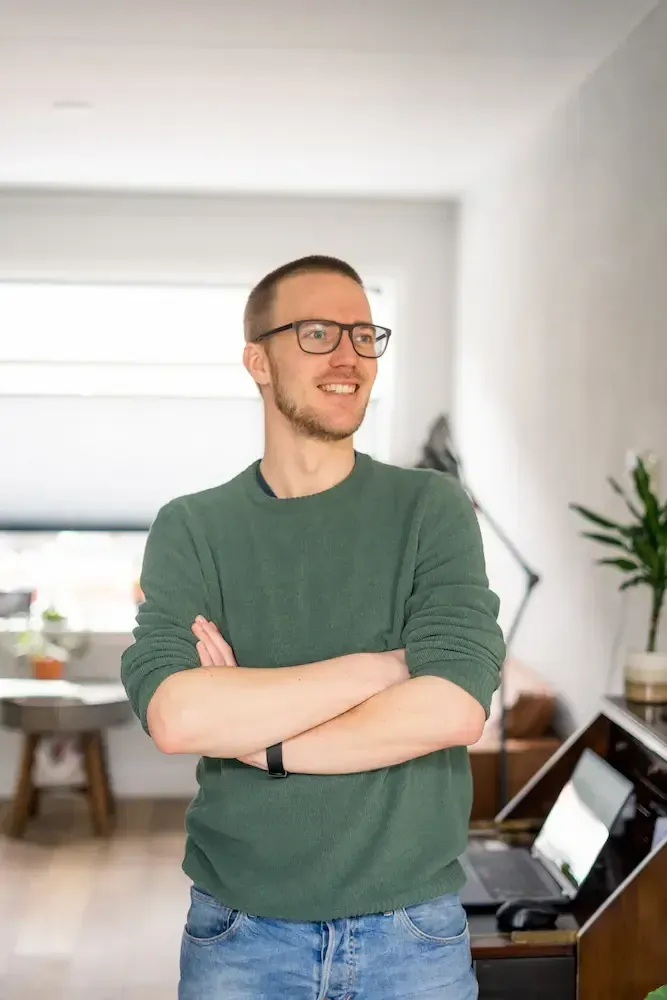 Niels Eric, freelance SEO-specialist, staand met de armen over elkaar in zijn werkruimte